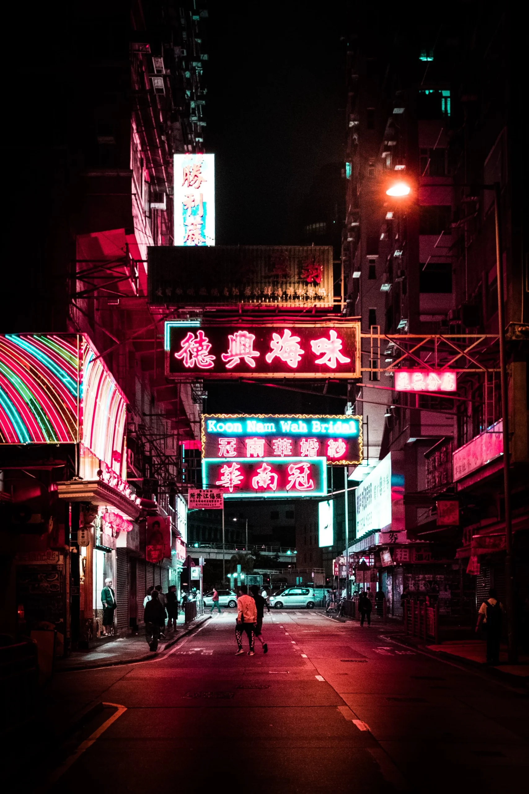 Night street scene with colorful neon signs in an urban area.