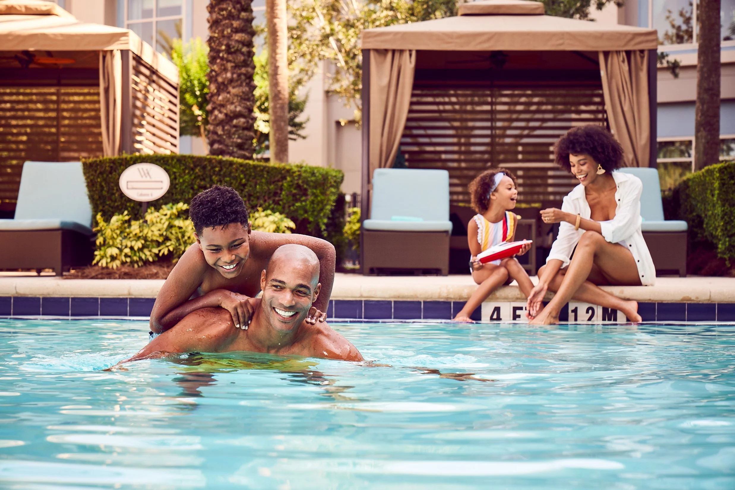 Parents and kids relaxing poolside during an effortless family vacation