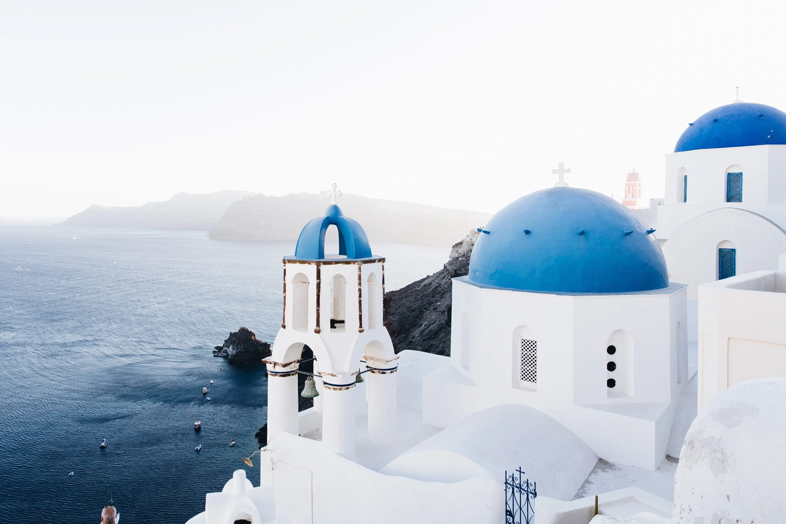 White buildings with blue domes overlooking the sea in Santorini, Greece.