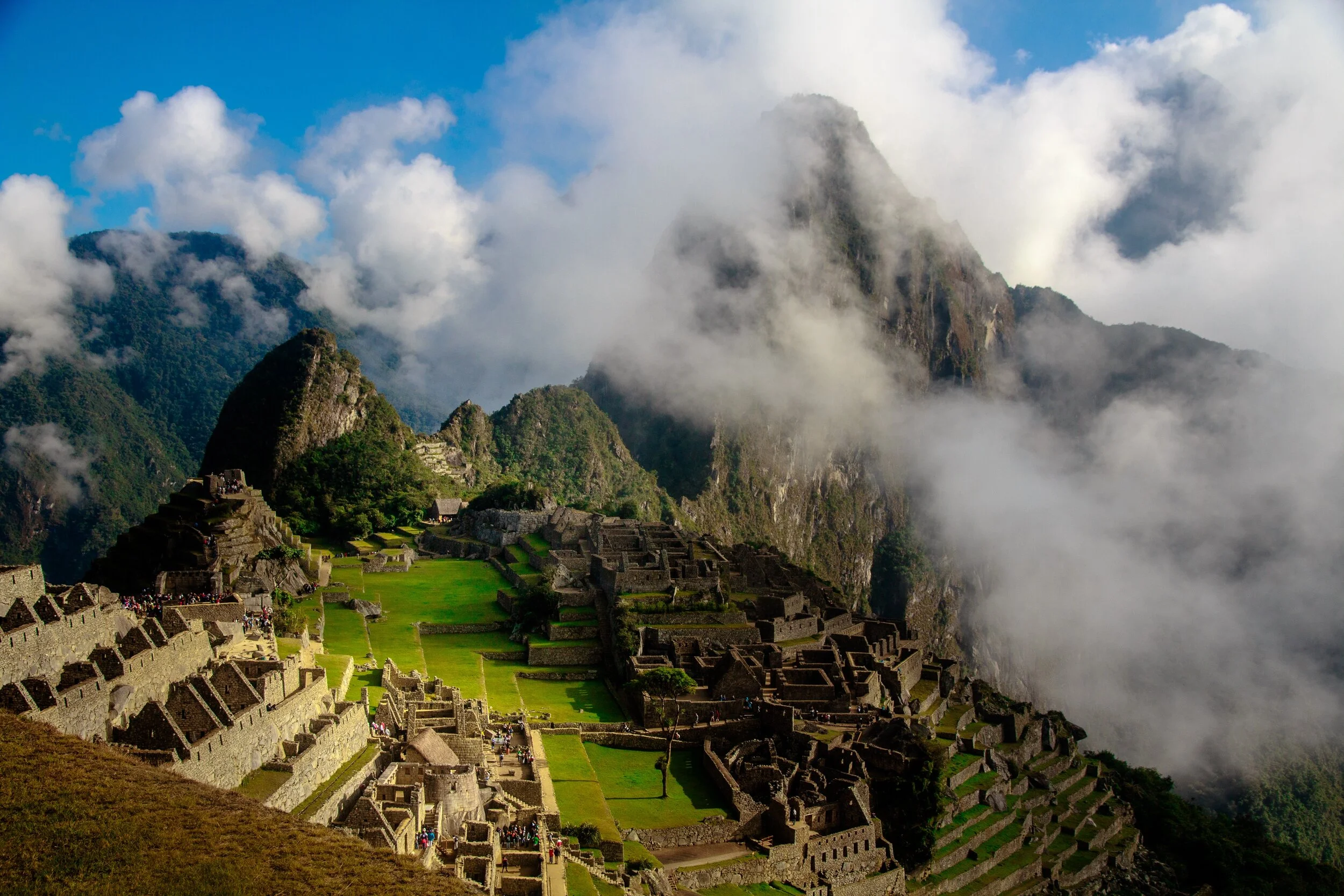 Machu Picchu ruins in Peru surrounded by mountains and clouds.